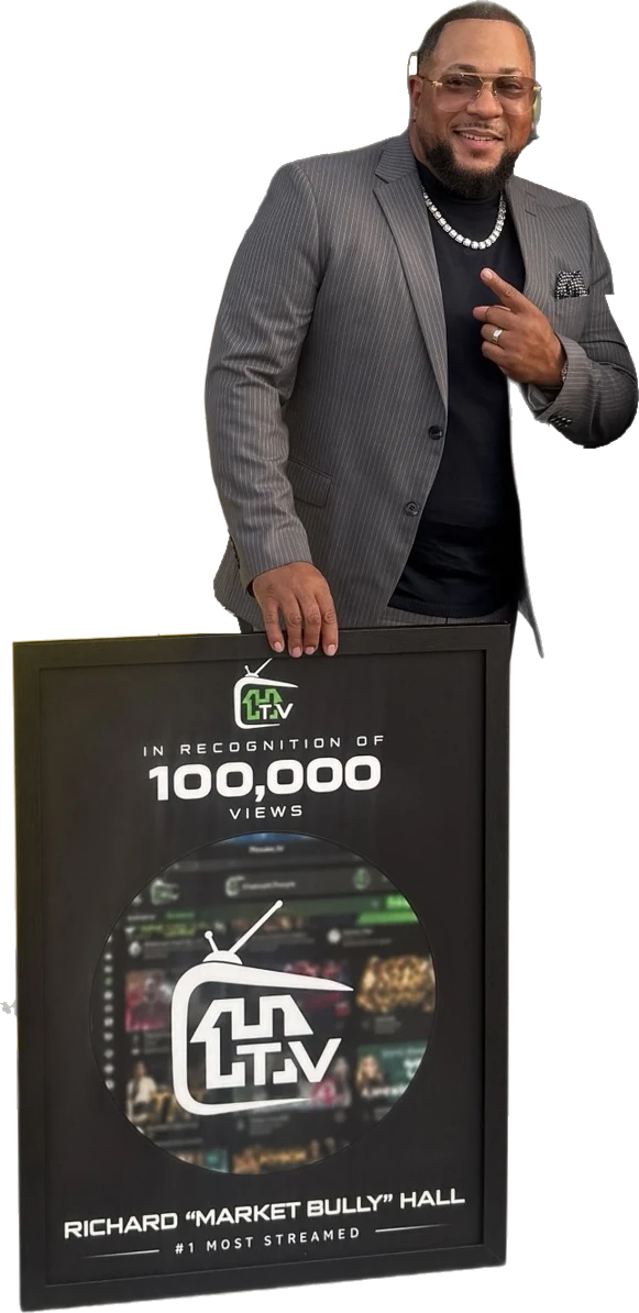 Richard Hall Jr. with his 1House.TV plaque. It reads: In recognition of 100,000 views. Richard Market Bully Hall. Number 1 Most Streamed.