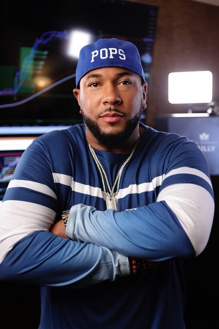 Portrait of Richard Hall Jr. in a blue cap that reads Pops, arms crossed